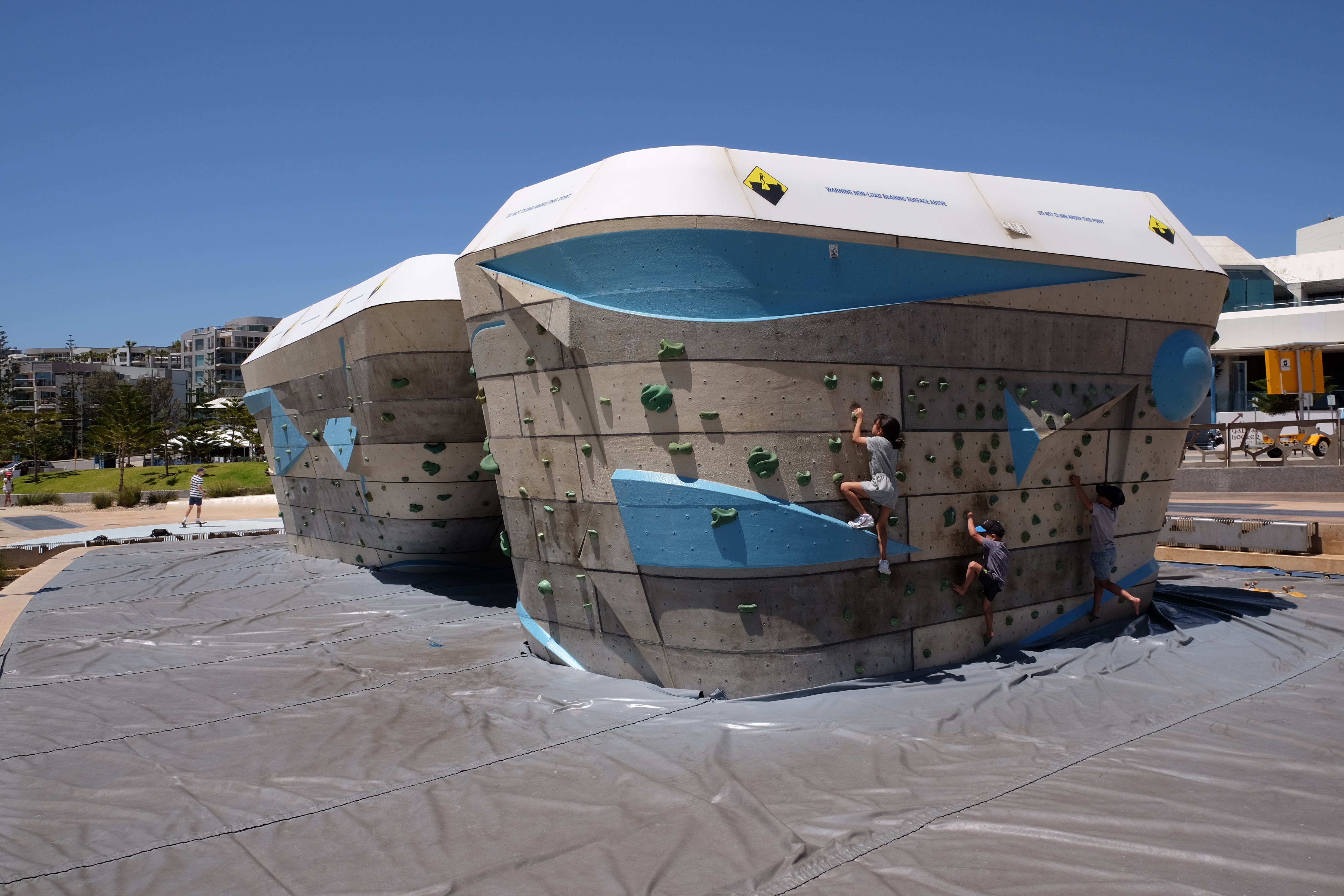 Image of a climbing wall in Scarborough, with softfall mats around the edges of the wall feature. The wall itself being a rectangular prism of approx 2m in height